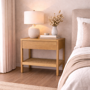 Bedroom with wooden nightstand, lamp, and decorative items.