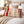 Decorative pillows with floral patterns on a bed in a bedroom setting.