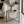 A round side table with a black metal frame and a patterned gray and white top, styled in a modern living room with a vase of greenery and a small bowl on top.